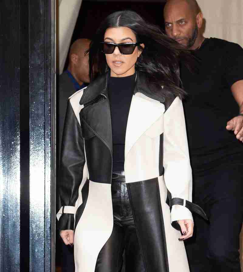 Kourtney Kardashian wearing a chess design leather trench coat - front