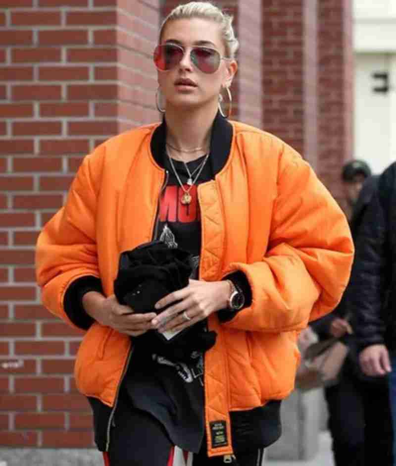 Hailey Bieber wearing an orange puffer jacket