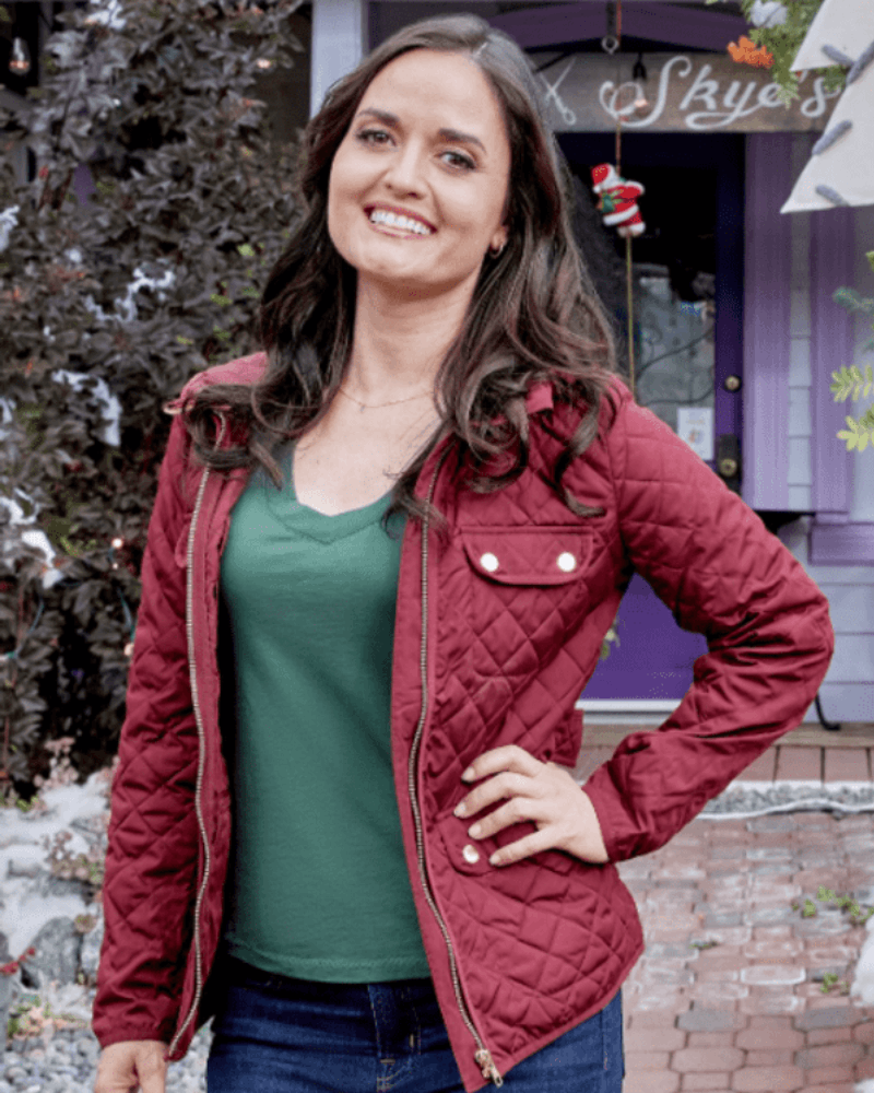 Danica Mckellar as Olivia Arden in You, Me & The Christmas Trees wearing a red quilted jacket