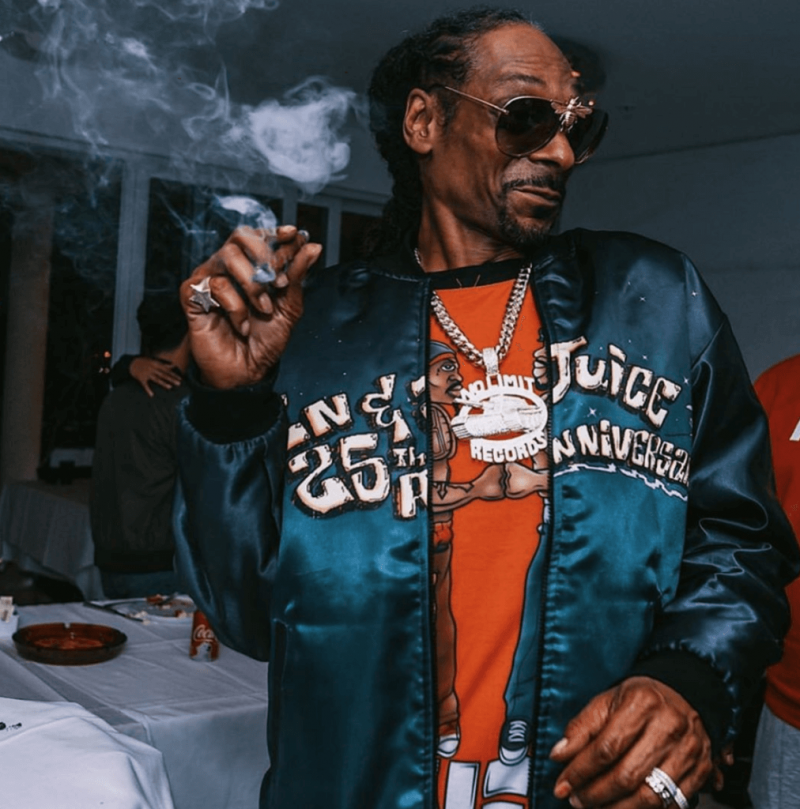 Snoop Dogg wearing his iconic gin an juice printed bomber jacket