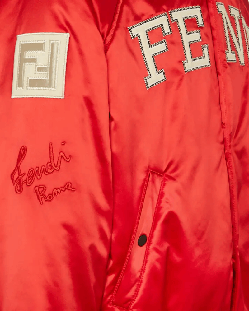 Embroidered patch on the right sleeve of The Kid Laroi's red satin varsity jacket